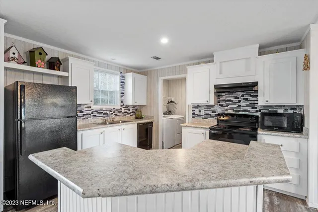 a kitchen with stainless steel appliances granite countertop a sink stove microwave and refrigerator