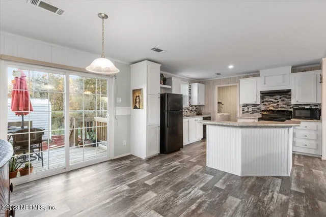 a kitchen with stainless steel appliances granite countertop a refrigerator a stove a sink dishwasher a oven with white cabinets and wooden floor