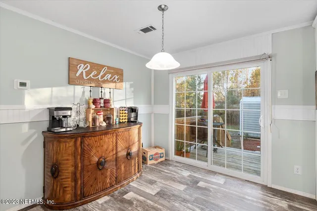 a kitchen with stainless steel appliances granite countertop a stove a sink dishwasher and a dining table with wooden cabinet