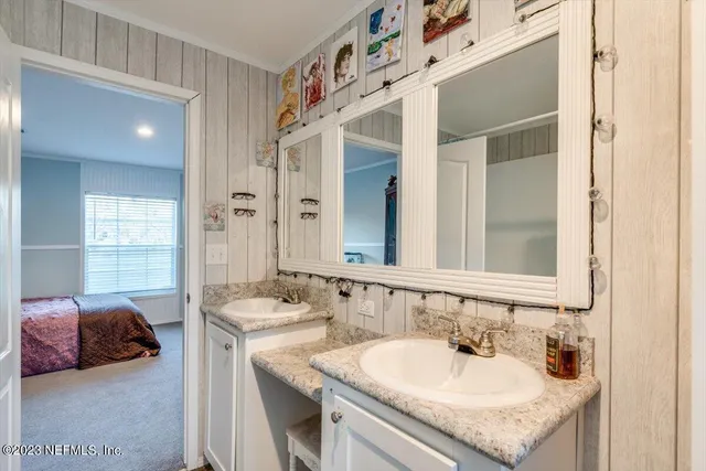 a en suite bathroom with a double vanity sink and a mirror