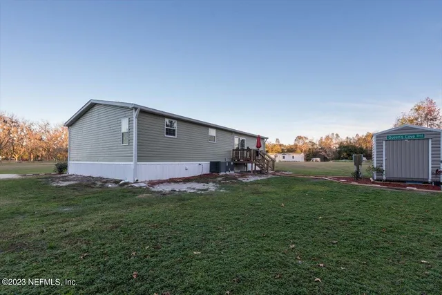 a backyard of a house with table and chairs