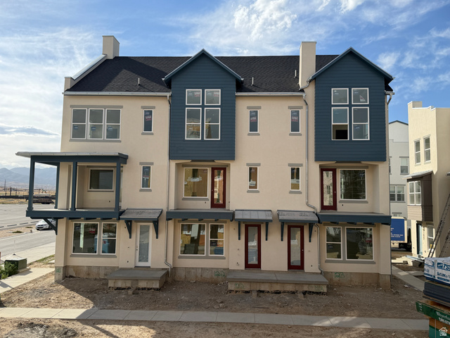 11021 South Freestone Road, Unit 121 South Jordan, UT 84009 - Photo 1 of 31 Contemporary townhome exterior featuring light-colored stucco, dark blue siding accents, and a multi-level design