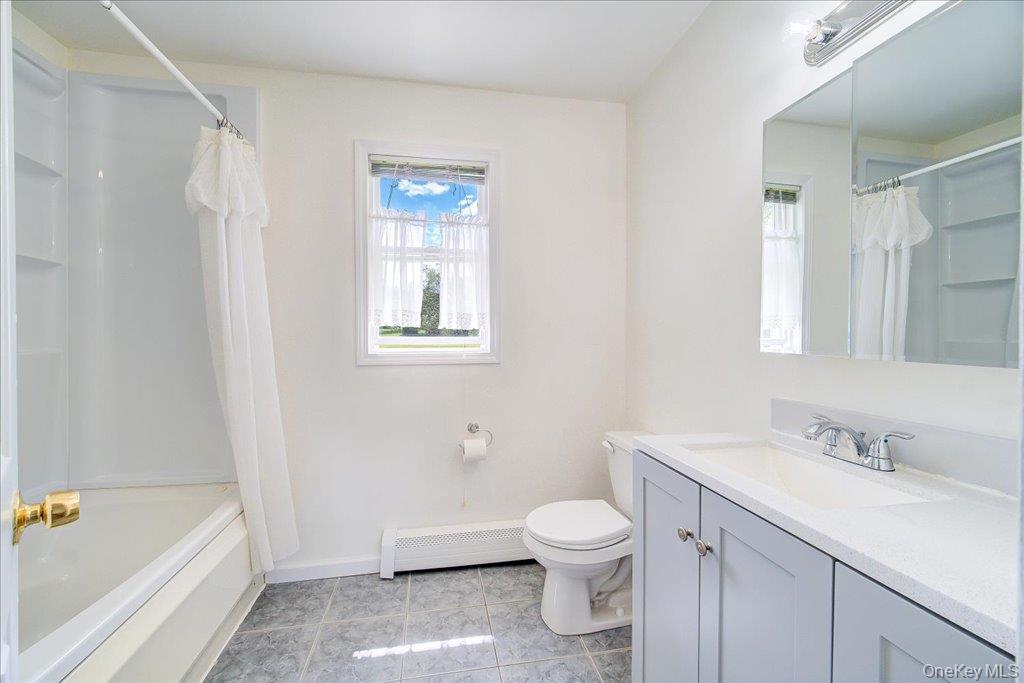 11 Catskill Avenue Monroe, NY 10950 - Photo 33 of 48 Bathroom with a baseboard heating unit, vanity, toilet, shower / bath combo with shower curtain, and baseboards