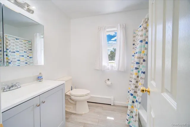 a bathroom with a sink a toilet and shower curtain