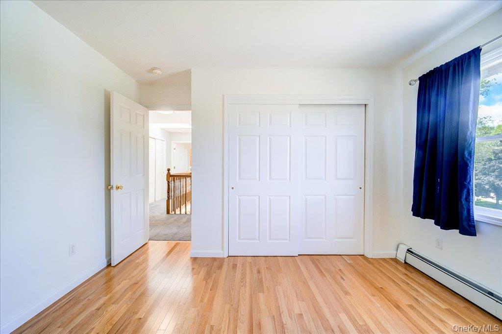 11 Catskill Avenue Monroe, NY 10950 - Photo 42 of 48 Unfurnished bedroom featuring a baseboard radiator, light wood finished floors, a closet, and baseboards