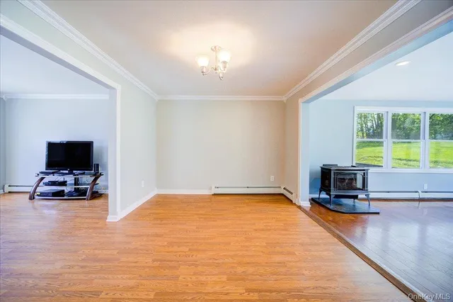 an empty room with floor to ceiling window and fireplace