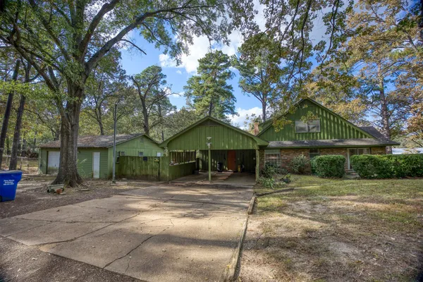 a front view of a house with a tree