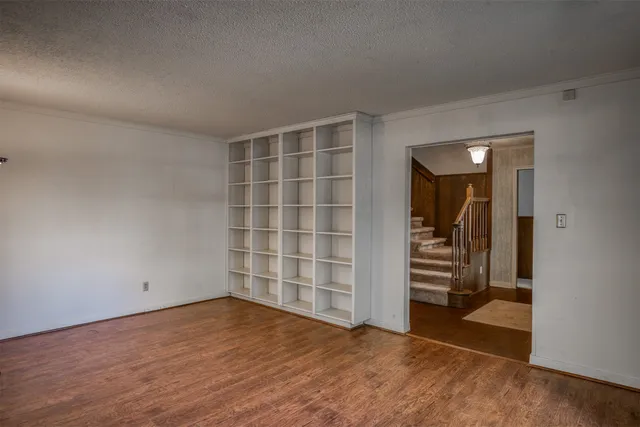 a kitchen with stainless steel appliances granite countertop a refrigerator a sink dishwasher a stove and white cabinets with wooden floor