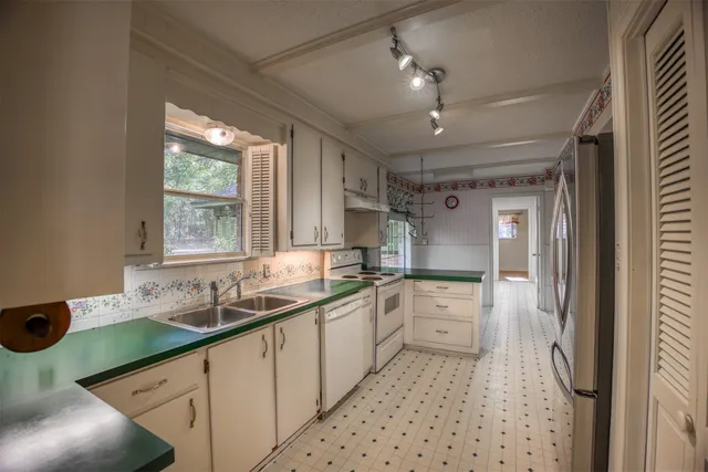 a kitchen with stainless steel appliances kitchen island granite countertop a refrigerator and a stove