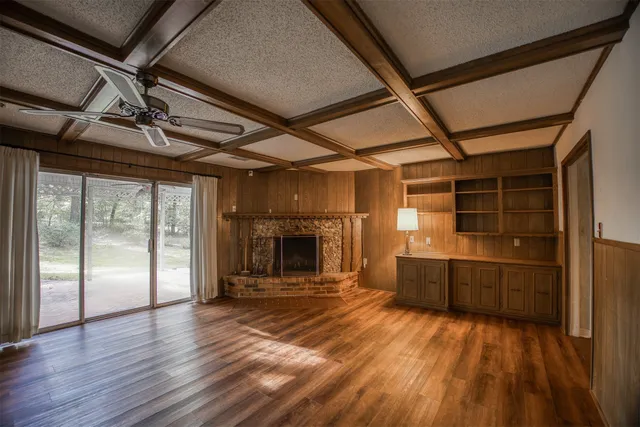 a view of empty room with wooden floor and fireplace