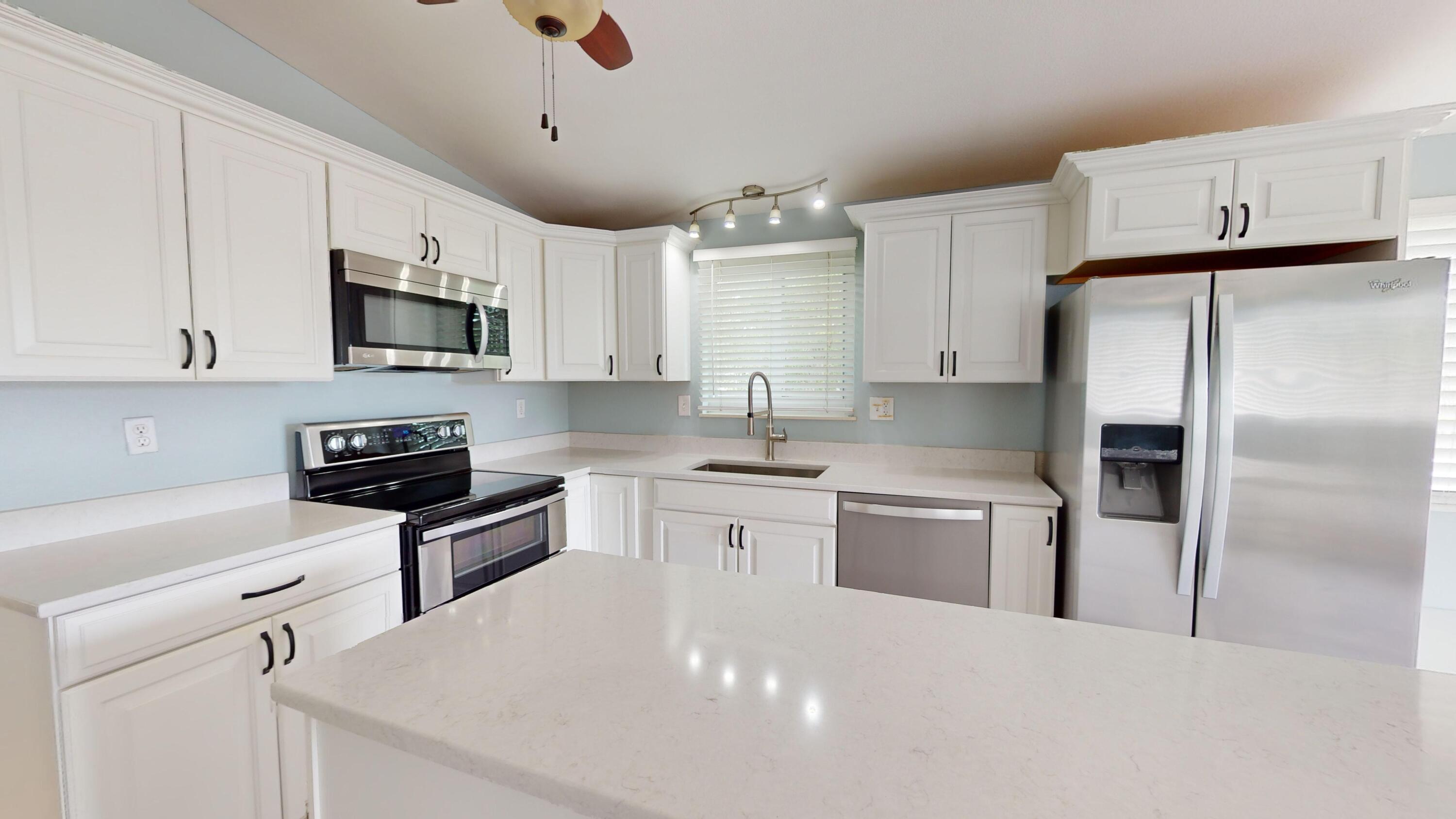 31163 Ave H Big Pine Key, FL 33043 - Photo 5 of 17 a kitchen with stainless steel appliances a stove a sink a refrigerator a microwave and cabinets
