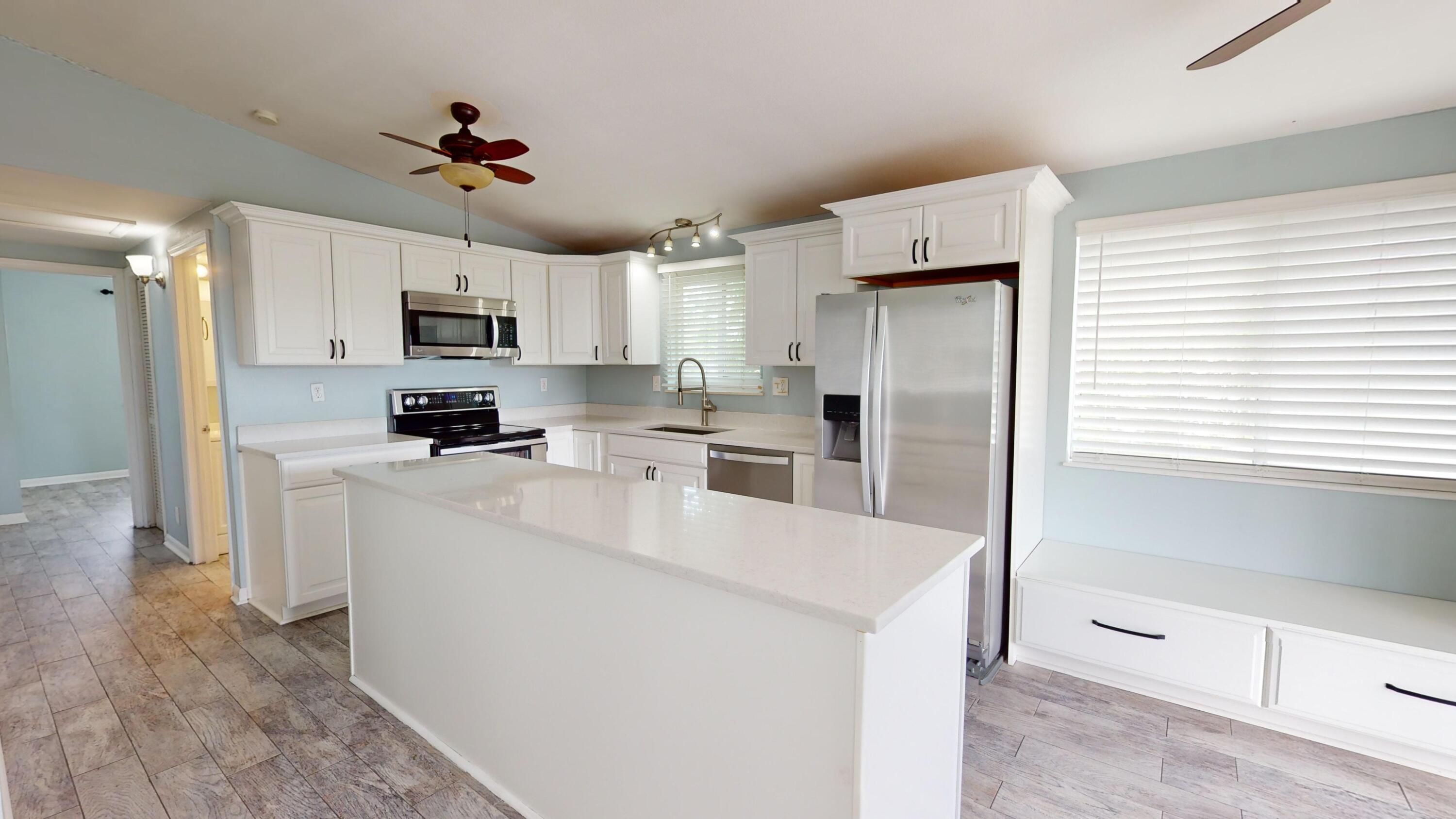 31163 Ave H Big Pine Key, FL 33043 - Photo 6 of 17 a kitchen with kitchen island a sink stainless steel appliances and cabinets