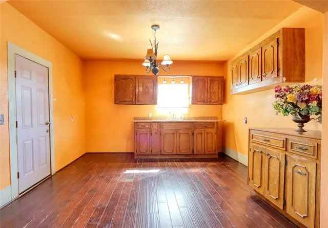 a kitchen with stainless steel appliances granite countertop a sink a stove a refrigerator and wooden floor