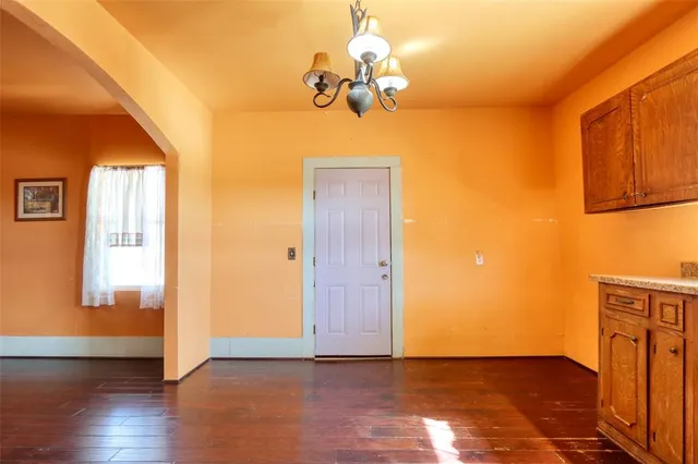 a view of a room with wooden floor and chandelier