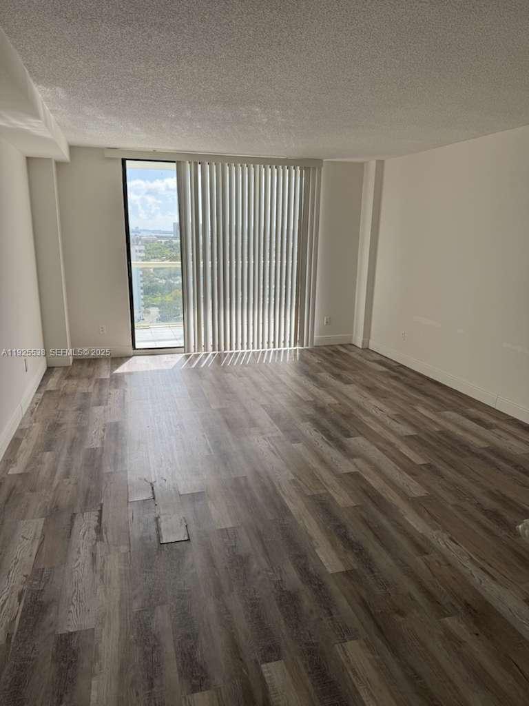 13499 Biscayne Boulevard, Unit 1404 North Miami, FL 33181 - Photo 1 of 13 an empty room with wooden floor and windows