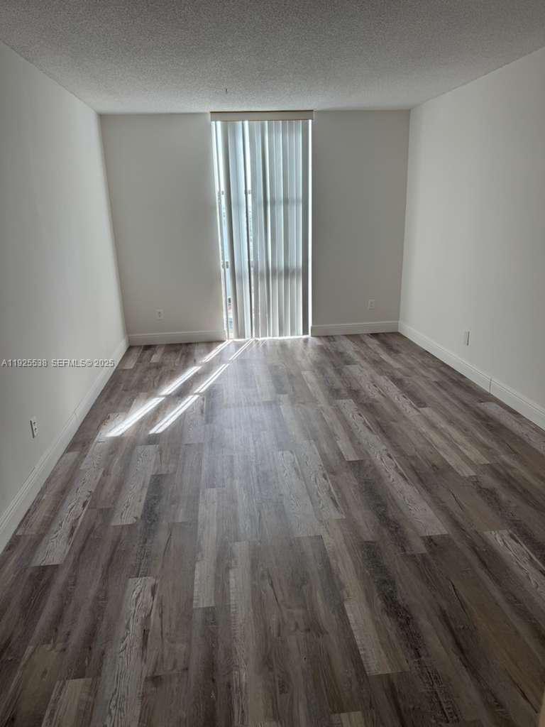 13499 Biscayne Boulevard, Unit 1404 North Miami, FL 33181 - Photo 3 of 13 a view of an empty room with wooden floor and a window