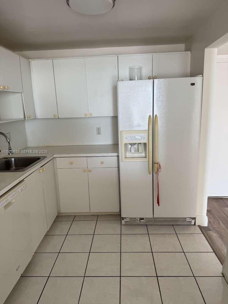13499 Biscayne Boulevard, Unit 1404 North Miami, FL 33181 - Photo 5 of 13 a kitchen with a refrigerator a stove top oven and cabinets