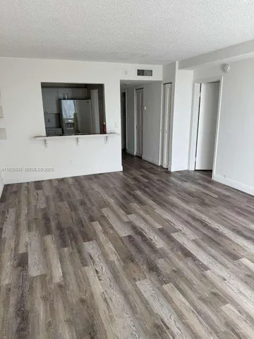 a view of a room with wooden floor and hallway