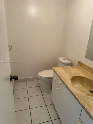 a bathroom with a granite countertop sink and a toilet