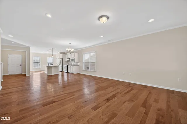 a view of empty room with wooden floor
