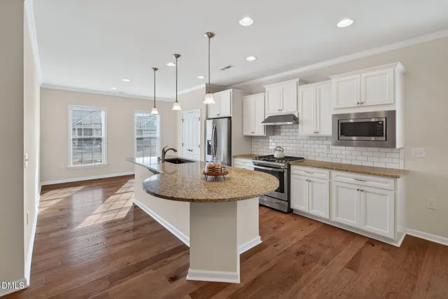 a kitchen with stainless steel appliances granite countertop a sink stove and wooden floor