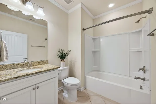 a bathroom with a granite countertop sink a toilet and shower