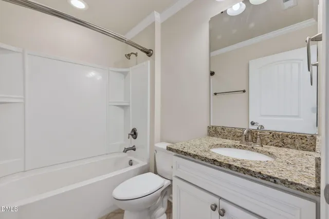 a bathroom with a granite countertop sink a toilet and shower