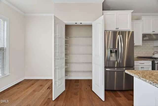 a kitchen with a refrigerator and a wooden floor