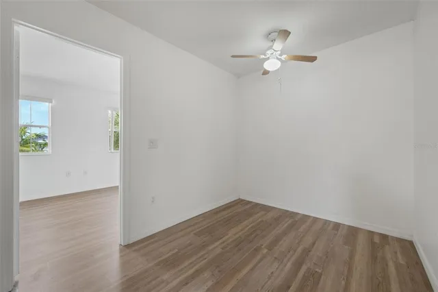 a view of a hallway with wooden floor and a living room