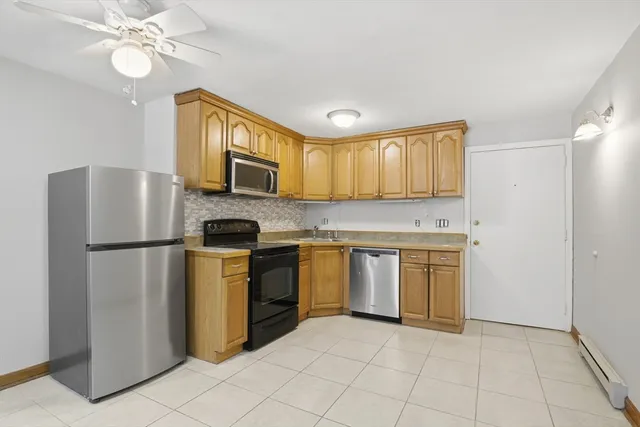 a kitchen with stainless steel appliances granite countertop a refrigerator a stove top oven a sink and dishwasher