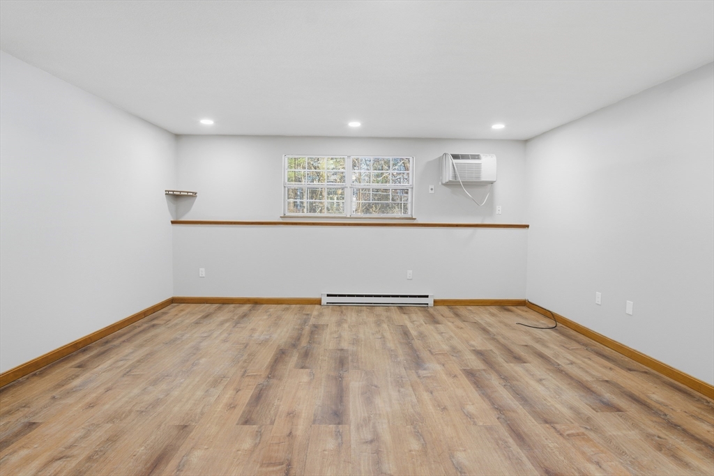 39 Pleasant Street, Unit 7 Northborough, MA 01532 - Photo 7 of 22 a view of an empty room with wooden floor and a window