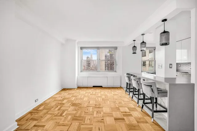 a big room with chandelier fan and windows