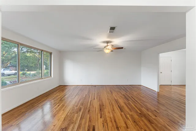 wooden floor in an empty room with a window