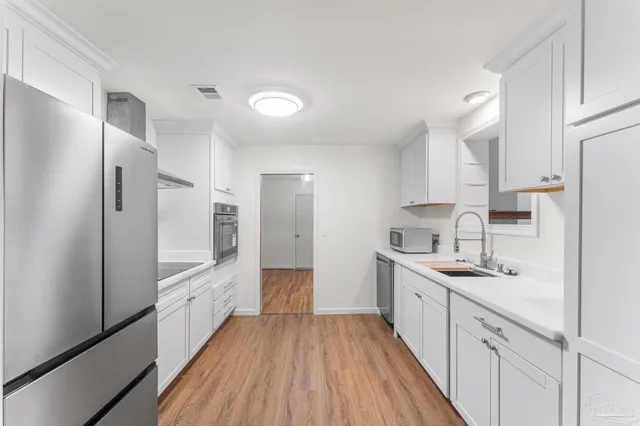 a kitchen with stainless steel appliances a sink stove and refrigerator