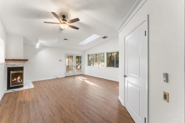 a view of an empty room with a fireplace and a window