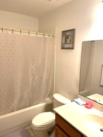 a white toilet sitting next to a white wall