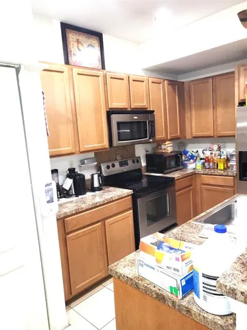 a kitchen with stainless steel appliances kitchen island granite countertop a sink and cabinets