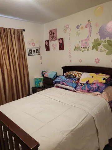 a bedroom with a bed and painting on the wall