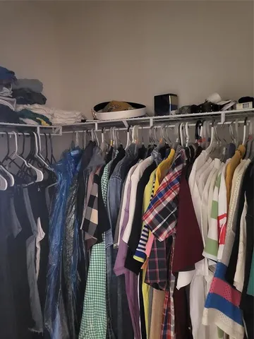 a view of walk in closet with clothes and shoes