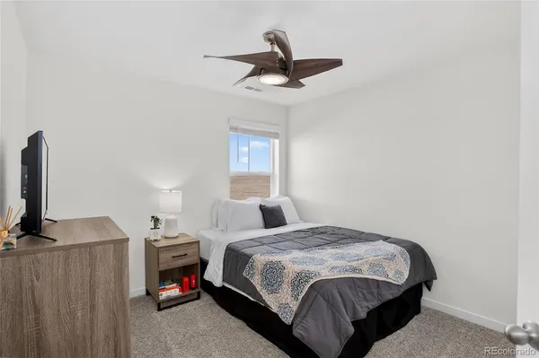a bedroom with a bed a chandelier and a window