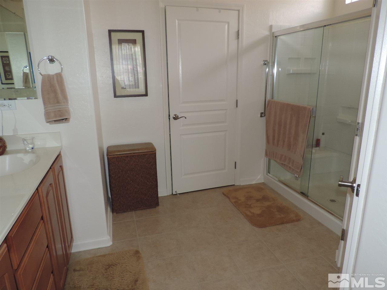 9101 Quilberry Way Reno, NV 89523 - Photo 11 of 20 a bathroom with a granite countertop shower a sink and a mirror