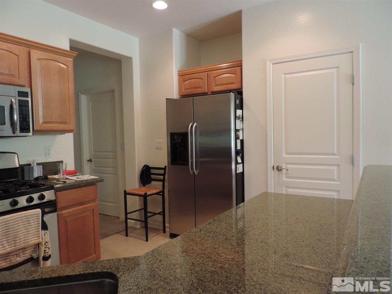 9101 Quilberry Way Reno, NV 89523 - Photo 16 of 20 a kitchen with stainless steel appliances granite countertop a refrigerator and a stove top oven