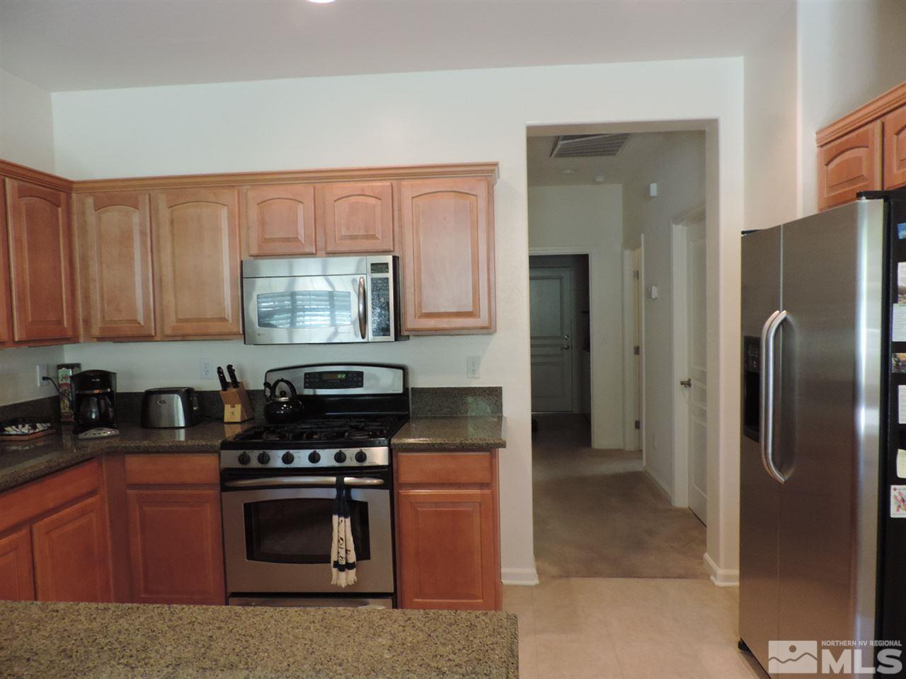 9101 Quilberry Way Reno, NV 89523 - Photo 17 of 20 a kitchen with stainless steel appliances granite countertop a refrigerator a stove and a sink