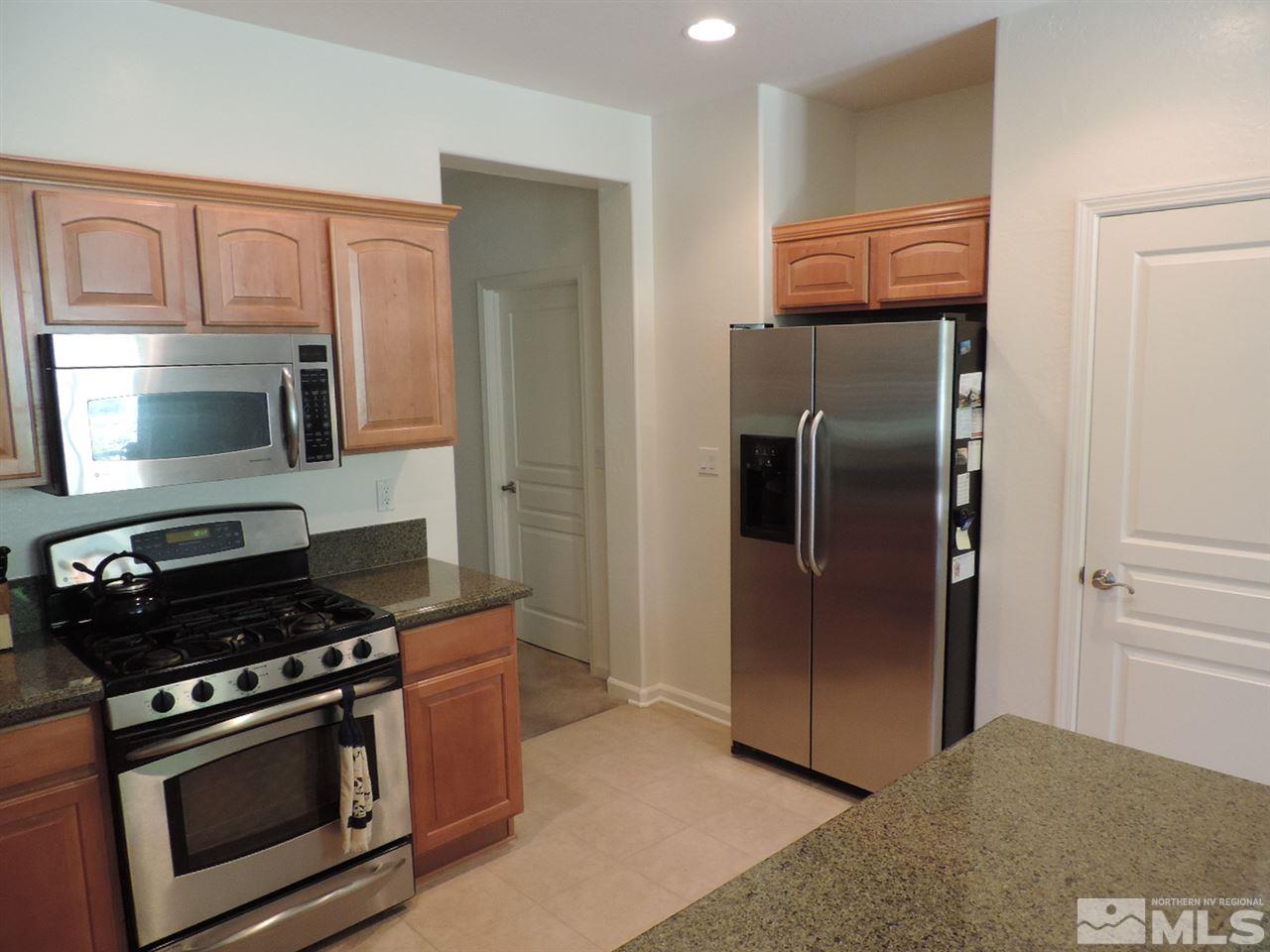 9101 Quilberry Way Reno, NV 89523 - Photo 6 of 20 a kitchen with stainless steel appliances granite countertop a refrigerator stove and microwave