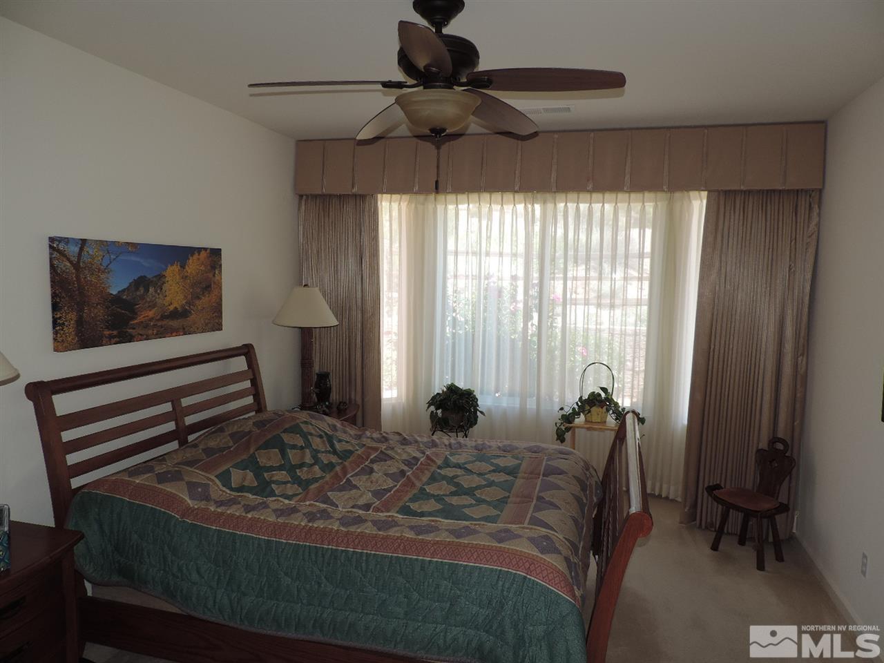 9101 Quilberry Way Reno, NV 89523 - Photo 9 of 20 a bedroom with a bed and a chandelier