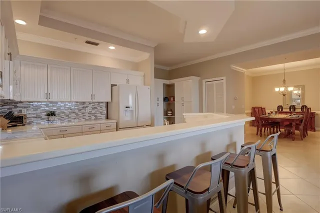 a large kitchen with lots of counter space and chairs