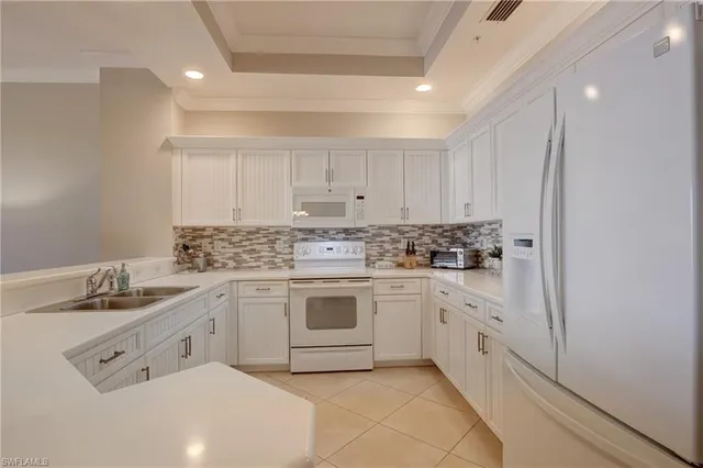 a kitchen with white cabinets stainless steel appliances and sink