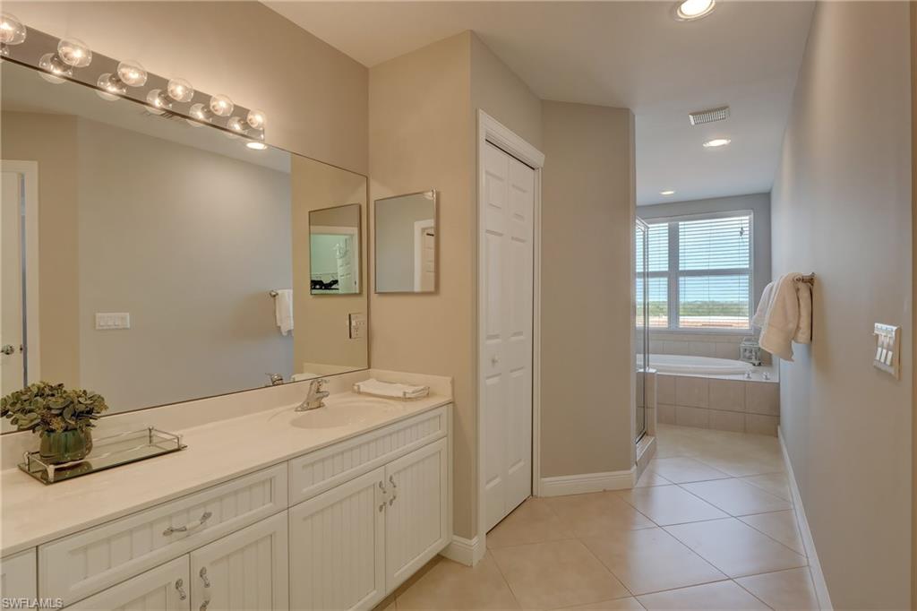 1857 San Marco Road, Unit PH3 Marco Island, FL 34145 - Photo 9 of 24 a en suite bathroom with a granite countertop sink a toilet a mirror and shower