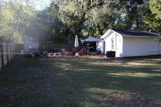 a view of backyard of house with outdoor seating and green space