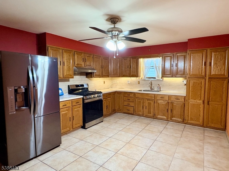 a kitchen with stainless steel appliances granite countertop a refrigerator sink and cabinets